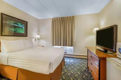 a hotel room with a bed and a flat screen tv at Travelodge by Wyndham Niagara Falls At the Falls in Niagara Falls