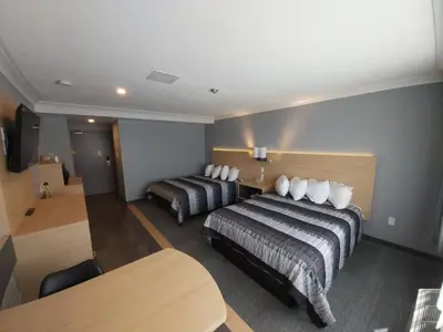a hotel room with two beds and a table at Americana Waterpark Resort & Spa in Niagara Falls