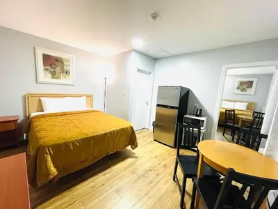 a bedroom with a bed and a table and a kitchen at A1 Inn Niagara Falls in Niagara Falls