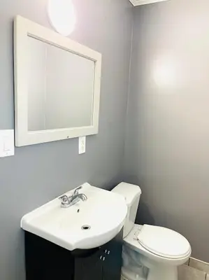 a bathroom with a sink and a toilet and a mirror at A1 Inn Niagara Falls in Niagara Falls