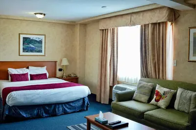 a hotel room with a bed and a couch at The Glengate Hotel & Suites in Niagara Falls