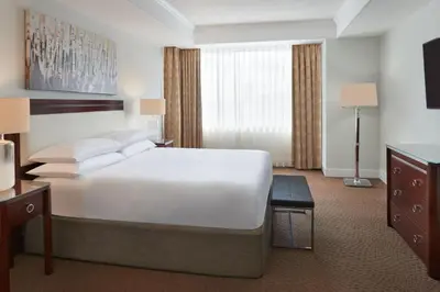 a hotel room with a large bed and a television at Sheraton Parkway Toronto North Hotel & Suites in Richmond Hill