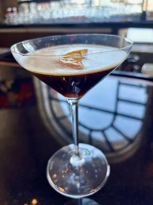 a martini glass with a brown liquid in it at Delta Hotels by Marriott London Armouries in London
