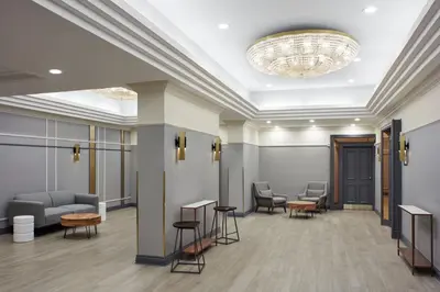 a lobby with chairs and a chandelier at Delta Hotels by Marriott London Armouries in London