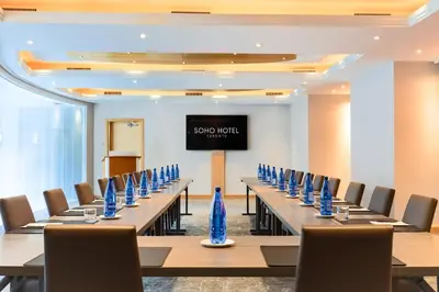 a conference room with long tables and blue vases at SoHo Hotel Toronto in Toronto