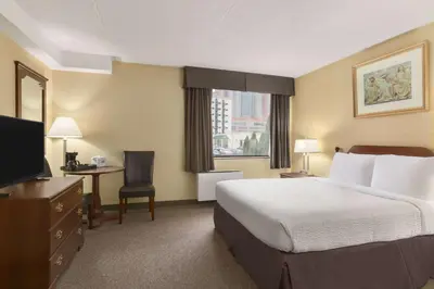 a hotel room with a bed and a television at Days Inn by Wyndham Fallsview in Niagara Falls