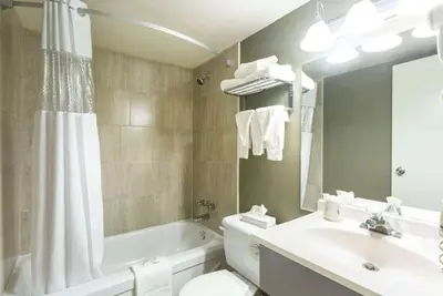 a bathroom with a tub and a sink and a toilet at Days Inn by Wyndham Fallsview in Niagara Falls