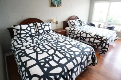 a bedroom with two beds with black and white comforters at Falcon Inn in Niagara Falls