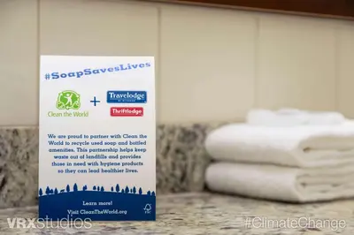 a sign in a bathroom with towels on a counter at Travelodge by Wyndham Richmond Hill in Richmond Hill
