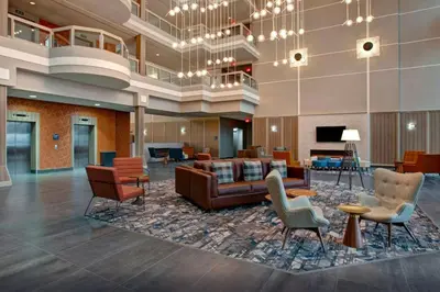 a lobby of a hotel with chairs and a couch at Four Points by Sheraton St. Catharines Niagara Suites in Thorold