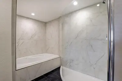 a white bathroom with a tub and a shower at Four Points by Sheraton St. Catharines Niagara Suites in Thorold