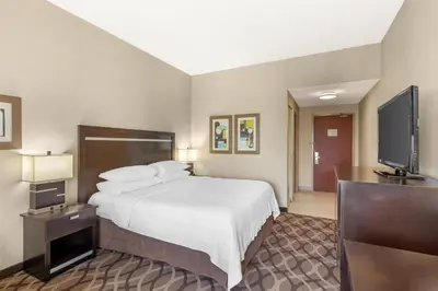 a hotel room with a bed and a flat screen tv at Best Western Plus Travel Hotel Toronto Airport in Toronto