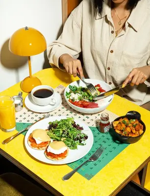 a woman sitting at a table with plates of food at The Drake Hotel in Toronto