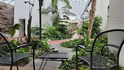 a patio with chairs and a garden with plants at Best Western Plus Lamplighter Inn & Conference Centre in London