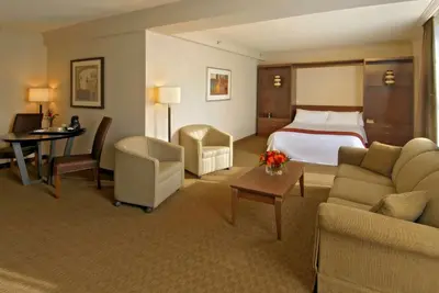a hotel room with a bed and a table and chairs at Best Western Plus Lamplighter Inn & Conference Centre in London