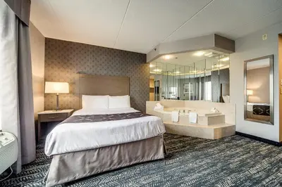 a hotel room with a bed and a bath tub at Monte Carlo Inn Brampton in Brampton