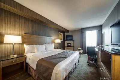 a hotel room with a large bed and a desk at Monte Carlo Inn Airport Suites in Mississauga