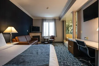 a hotel room with a bed and a living room at Monte Carlo Inn Toronto West Suites in Mississauga