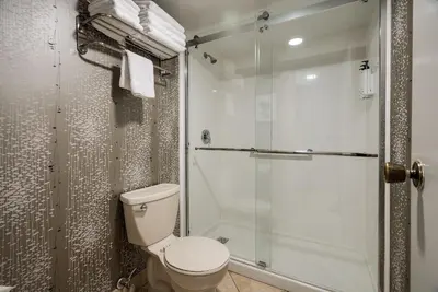 a bathroom with a toilet and a shower at Monte Carlo Inn Toronto West Suites in Mississauga