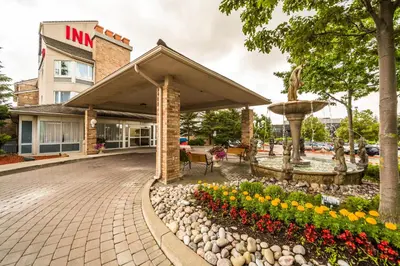 a hotel exterior with a fountain and flowers at Monte Carlo Inn Markham in Markham