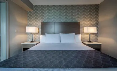 a bedroom with a large bed with two lamps at Monte Carlo Inn Markham in Markham