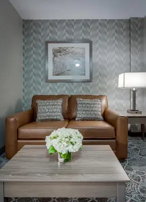 a living room with a brown couch and a table at Monte Carlo Inn Markham in Markham