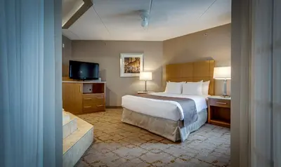 a hotel room with a bed and a television at Monte Carlo Inn Vaughan Suites in Vaughan