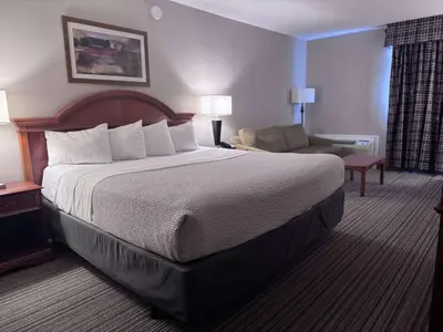 a hotel room with a large bed and a couch at Ramada by Wyndham London in London