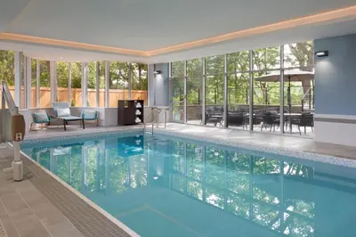 a large swimming pool with blue water in a building at TownePlace Suites by Marriott Toronto Oakville in Oakville