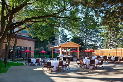 a group of tables and chairs with red umbrellas at Four Points by Sheraton Toronto Airport in Mississauga