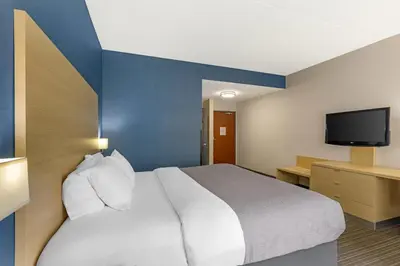 a hotel room with a bed and a flat screen tv at Quality Inn & Suites Oakville-Mississauga in Oakville