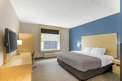 a hotel room with a bed and a flat screen tv at Quality Inn & Suites Oakville-Mississauga in Oakville