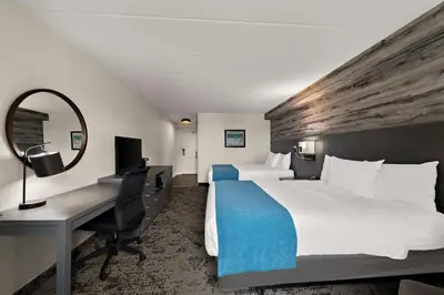 a hotel room with two beds and a desk at Best Western Parkway Hotel Toronto North in Richmond Hill