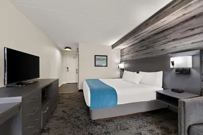 a hotel room with a bed and a flat screen tv at Best Western Parkway Hotel Toronto North in Richmond Hill