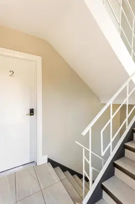 a staircase in a house with a white stair case at ENTIRE 2 BEDROOM APARTMENT DOWNTOWN - u2 in Kitchener