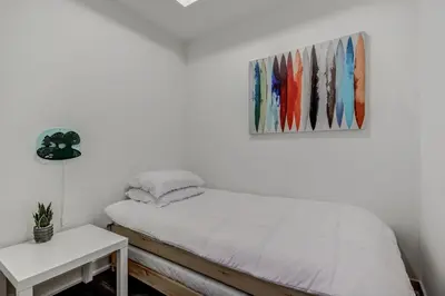 a bedroom with a bed and a painting on the wall at The Benetton Suite - Square One 1 BR + Den + 1 Parking in Mississauga