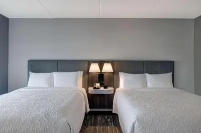 two beds in a hotel room with white sheets at Hampton Inn & Suites Burlington, Ontario, Canada in Burlington
