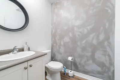 a bathroom with a toilet and a sink and a mirror at GlobalStay Waterfront 5 Bedroom Townhouse Hot tub Sauna Stoney Creek in Hamilton