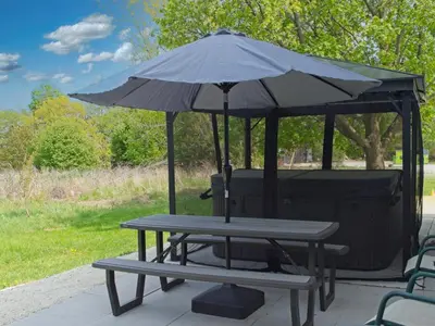 a picnic table with an umbrella on top of it at 6BR Blue Mountain Chalet Hot Tub Updated Walk to Village Fun in Blue Mountains