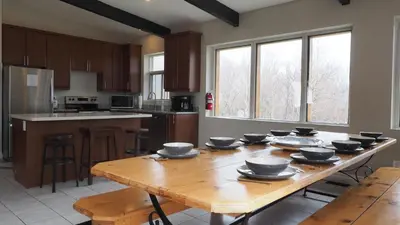 a kitchen with a wooden table with bowls on it at 6BR Blue Mountain Chalet Hot Tub Updated Walk to Village Fun in Blue Mountains