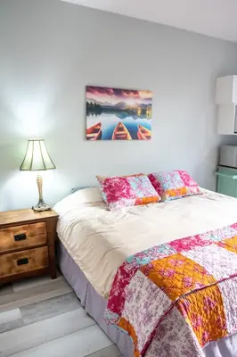 a bedroom with a bed and a table with a lamp at The Jypsy Inn / Muskoka in Bracebridge