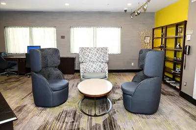 a waiting room with chairs and a table and a desk at Courtyard by Marriott Toronto Brampton in Brampton