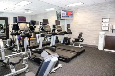 a gym with rows of tread machines and a tv at Courtyard by Marriott Toronto Brampton in Brampton