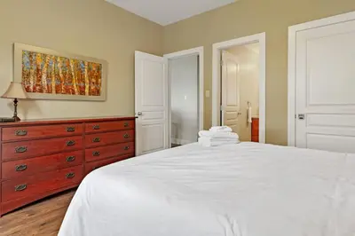 a bedroom with a white bed and a dresser at Blue Mountain Getaway Located on Golf Course in Blue Mountains