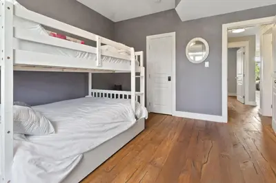 a bedroom with white bunk beds and a wooden floor at Rivergrass Townhouse in Blue with Pool Golf Skiing - 219 Rivergrass in Blue Mountains