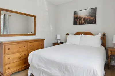 a bedroom with a bed with a mirror and a dresser at 3BR Snowbridge Chalet in Blue with Golf Course View in Collingwood