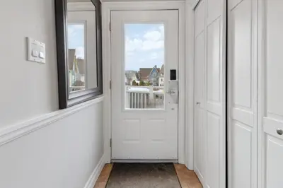 a hallway with a white door and a window at 3BR Snowbridge Chalet in Blue with Golf Course View in Collingwood