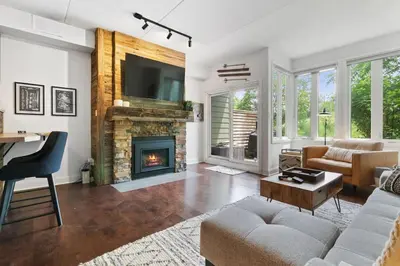 a living room with a couch and a fireplace at Modern Mountainside Ski in Ski out 87111 in Blue Mountains