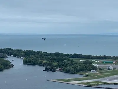 an airplane is flying over a river with trees at Magnificient View next CN Tower/Rogers/Union/MTCC in Toronto