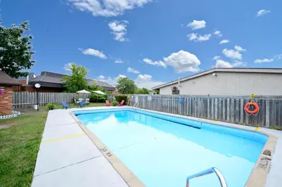 a swimming pool in a yard with a fence at Canadas Best Value Inn St. Catharines in St. Catharines